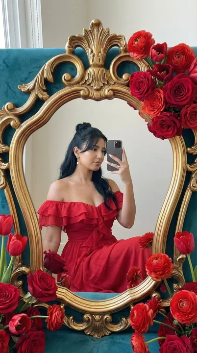 Jeune fille dans un miroir vintage entouré de roses baroques rouges