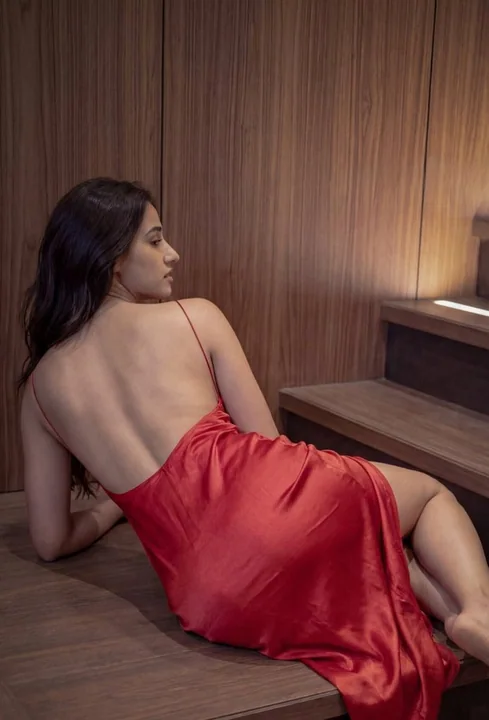 Red dress, lazy beauty on the dark wooden staircase