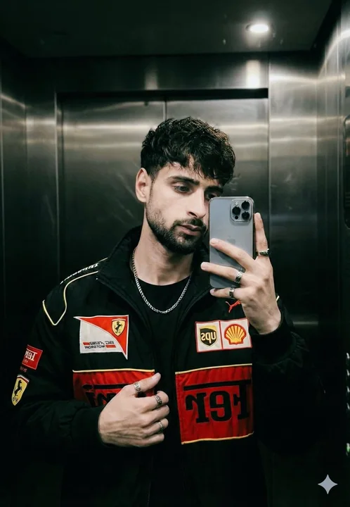 Jeune pilote de Formule 1 prenant une photo de lui-même dans le miroir de l'ascenseur