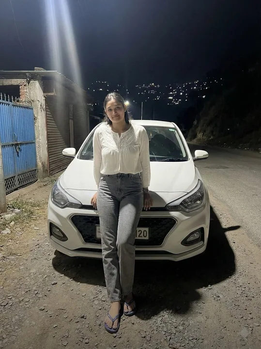 夜幕の光柱の下の車前の人像