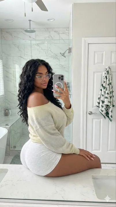 Jeune fille élégante prenant une photo de profil languissante devant le miroir de la salle de bains