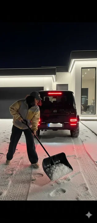 Mercedes devant la demeure de luxe dans une nuit neigeuse et la jeune fille qui déblaye la neige