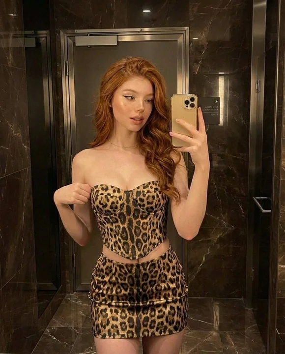 Warm light bathroom red-haired girl leopard print outfit self-portrait