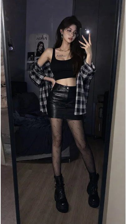 Photo en pied d’une influenceuse sexy, style streetwear tendance, prise de profil dans une chambre