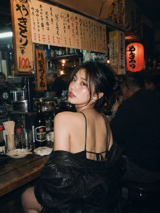 Cinematic atmospheric photoshoot of a beautiful East Asian woman in red at an izakaya