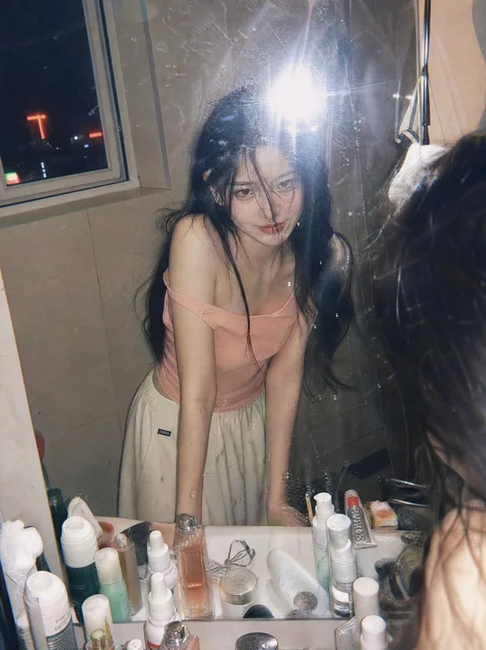 Vintage film-style atmospheric portrait of a girl in front of a bathroom mirror