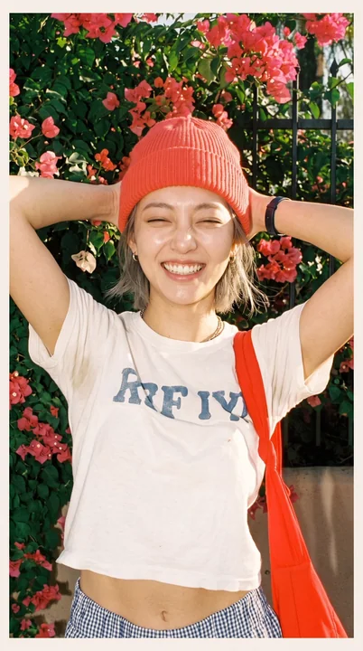 艳阳下九重葛花墙前开怀大笑的女性