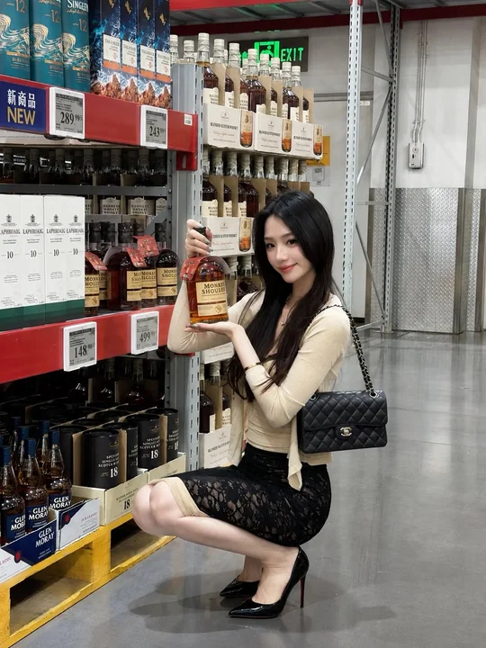 仓储超市蹲姿挑选酒水的东亚女性写实街拍
