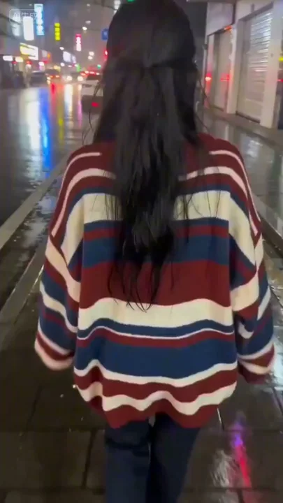 雨の夜、ネオンが輝く街頭で、カメラを構えた彼女の甘い微笑みと振り返る姿