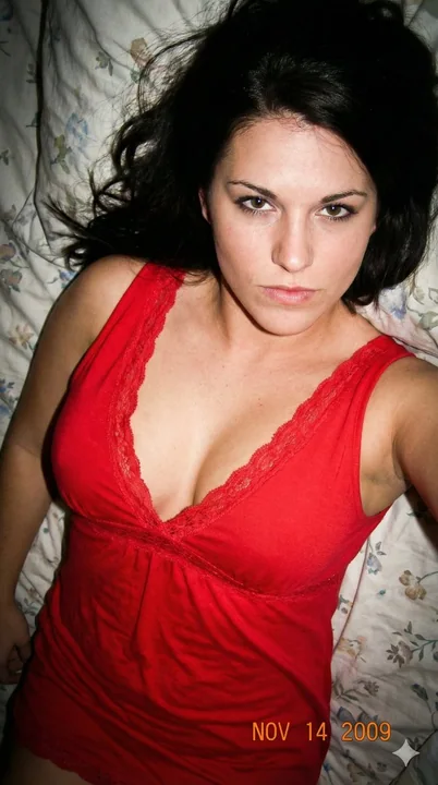 Jeune fille élégante en robe rouge sous un flash de caméra CCD vintage