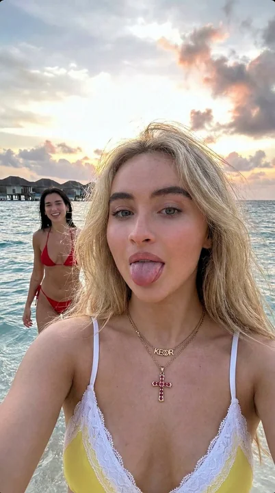 Blond girl on Maldives beach takes playful selfie with Dua Lipa