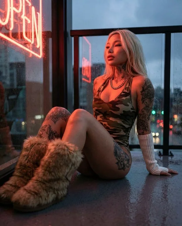 Éditorial de mode néon avec tatouage camouflage sur un balcon par une nuit de pluie torrentielle