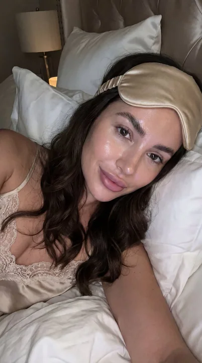 A makeup-free selfie in a luxurious bedroom after late-night skincare