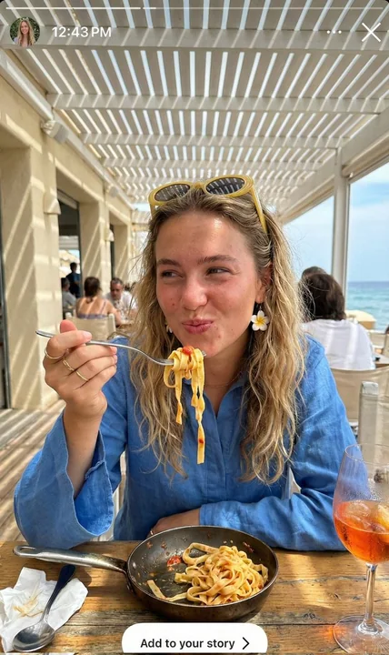 A Mediterranean vacation girl twirling spaghetti under dappled sunlight