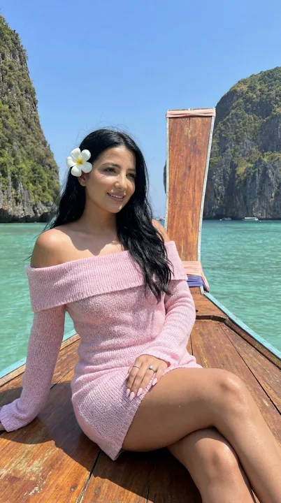 Dreamy travel portrait photos in a pink dress on a long-tail boat against the blue sea and sky